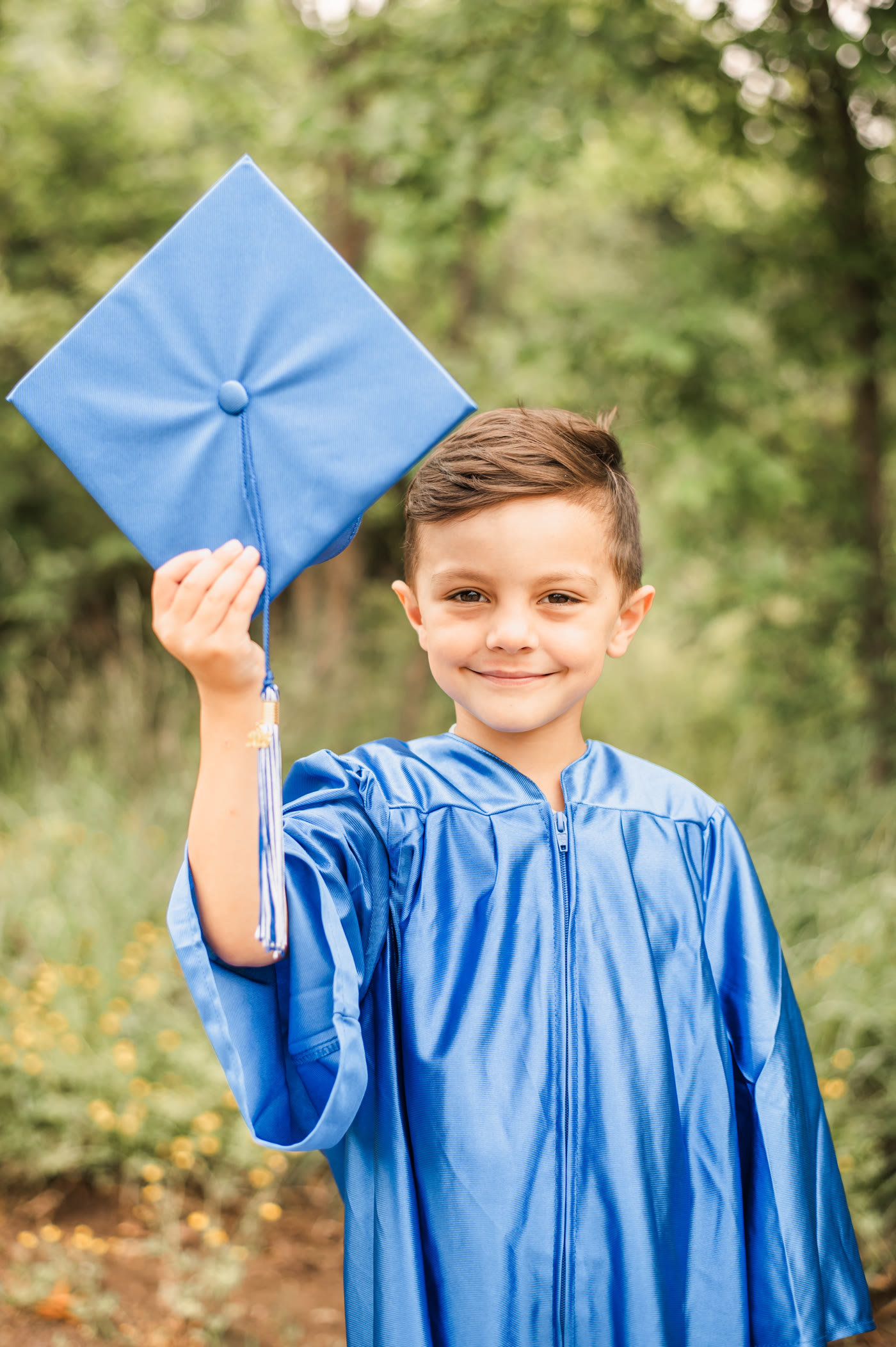 A joyful Amaze Academy graduate in a blue cap and gown